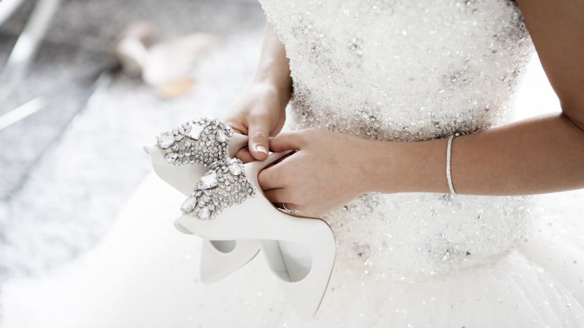 Braut hält Schuhe in den Händen