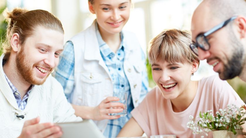 Zwei Paare sitzen vor Laptop