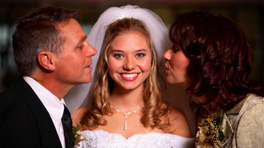 Braut wird von Eltern geküsst
