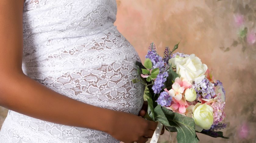 Schwangere Braut mit Blumenstrauss