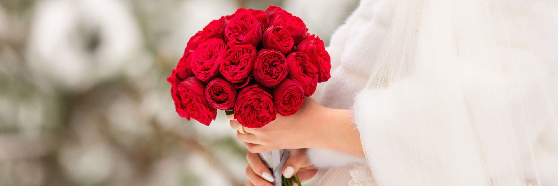 Warm gekleidete Braut mit Brautstrauss aus roten Rosen